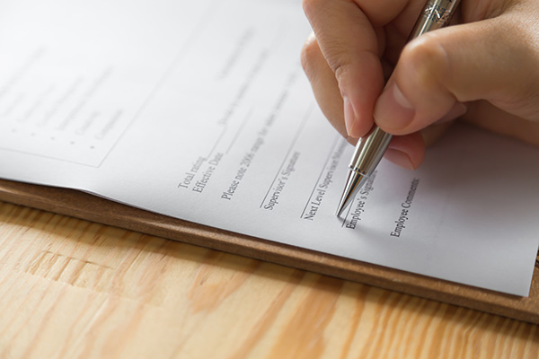 Hand with pen over application form